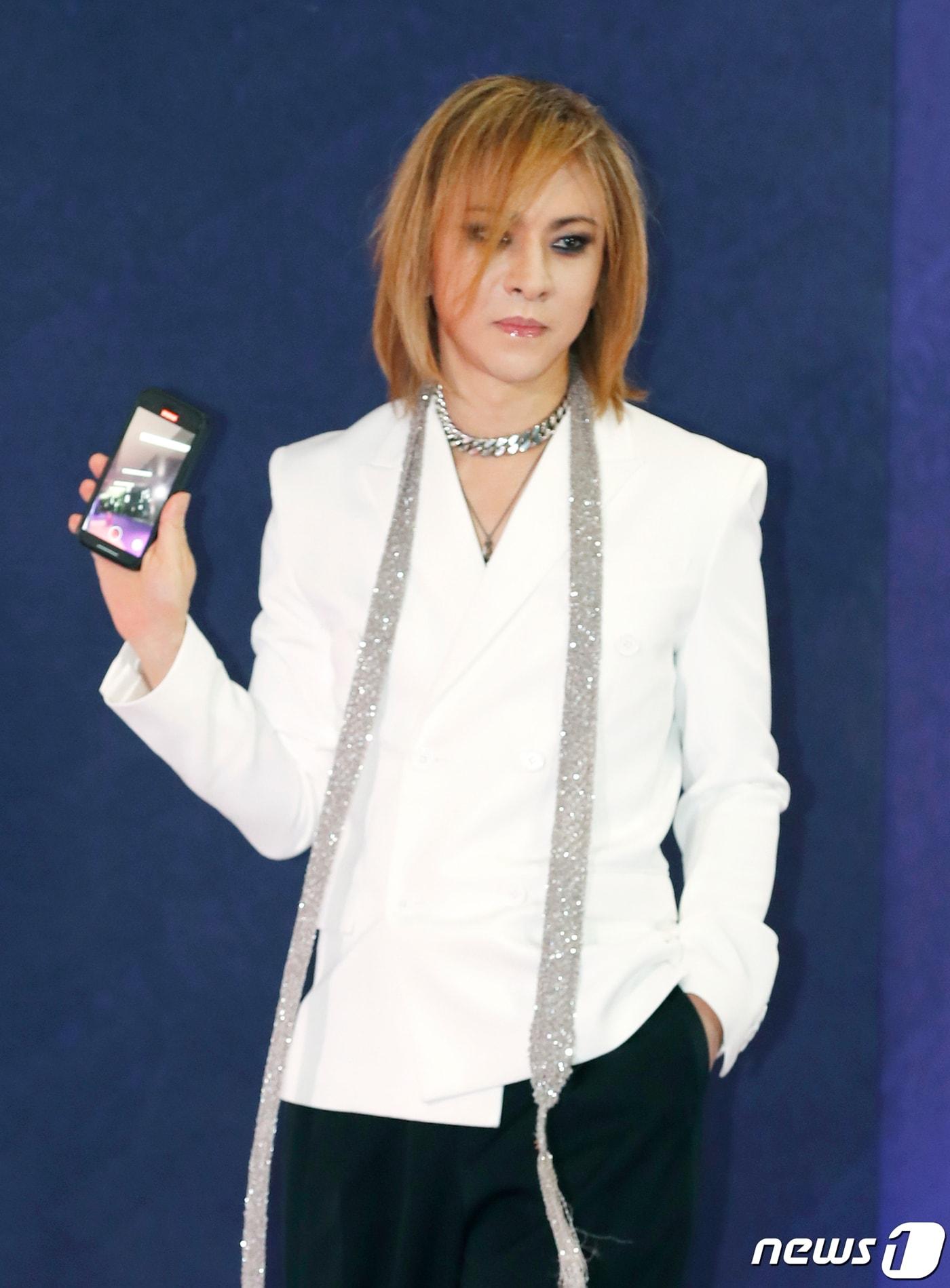 본문 이미지 - 일본 밴드 X-JAPAN(엑스재팬) 리더 요시키가 28일 일본 도쿄돔에서 열린 ‘2023 마마 어워즈(2023 MAMA AWARDS)’에서 핑크 카펫을 밟으며 현장을 핸드폰에 담고 있다. 2023.11.28/뉴스1 ⓒ News1 권현진 기자