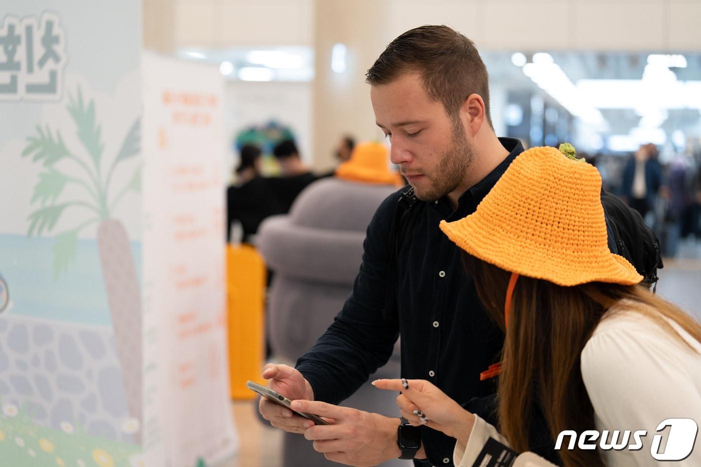 제주공항에서 친환경여행 서약하는 외국인 관광객.(제주도 제공)