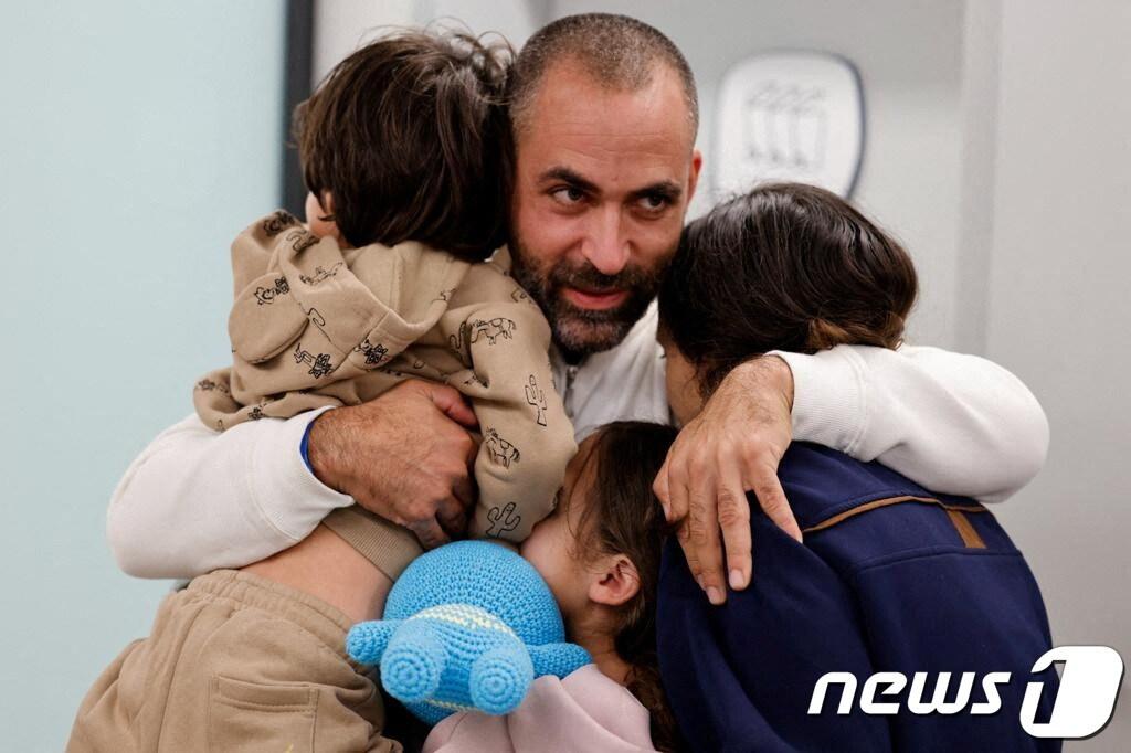 본문 이미지 - 팔레스타인 무장 정파 하마스에 억류되었다가 풀려난 브로더치 삼남매가 26일(현지시간) 이스라엘 페타크 티크바 지역에 있는 슈나이더 아동 의료 센터에서 아빠와 상봉하며 서로 껴안고 있다. 2023.11.26 ⓒ 로이터=뉴스1 ⓒ News1 정지윤 기자