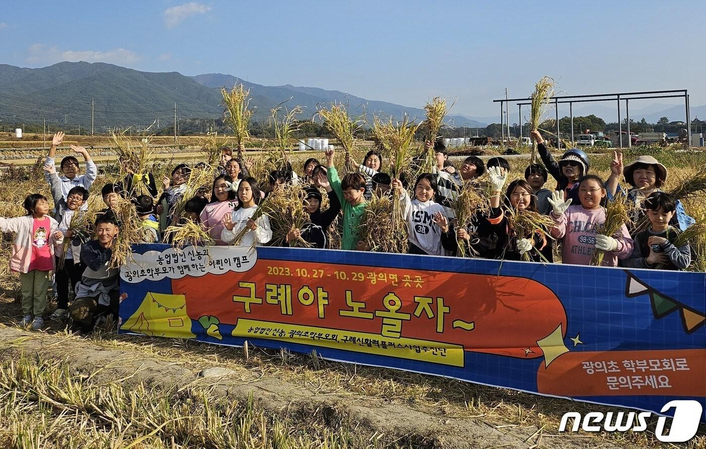 본문 이미지 -  구례 광의초등학교(교장 노형도)- 학생들이 직접 모내기한 벼를 전통방식으로 추수한 뒤 벼를 들고 단체사진을 촬영하고 있다.(전남교육청 제공)/뉴스1 