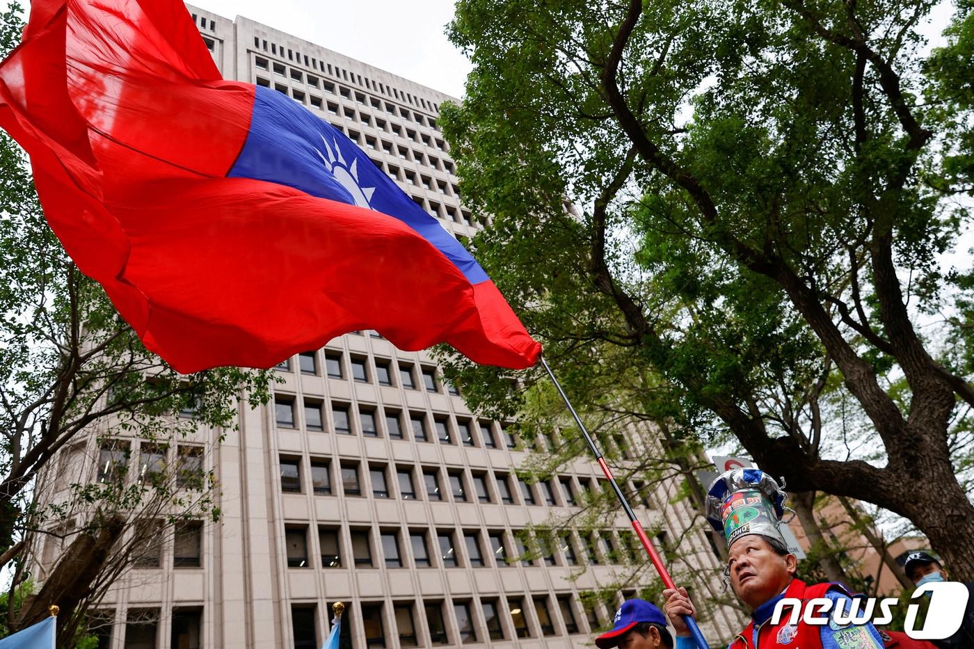 본문 이미지 - 대만 타이베이 선거관리위원회 건물 밖에서 제1야당 국민당 지지자 국기를 흔들고 있는 모습. 2023.11.24. ⓒ 로이터=뉴스1