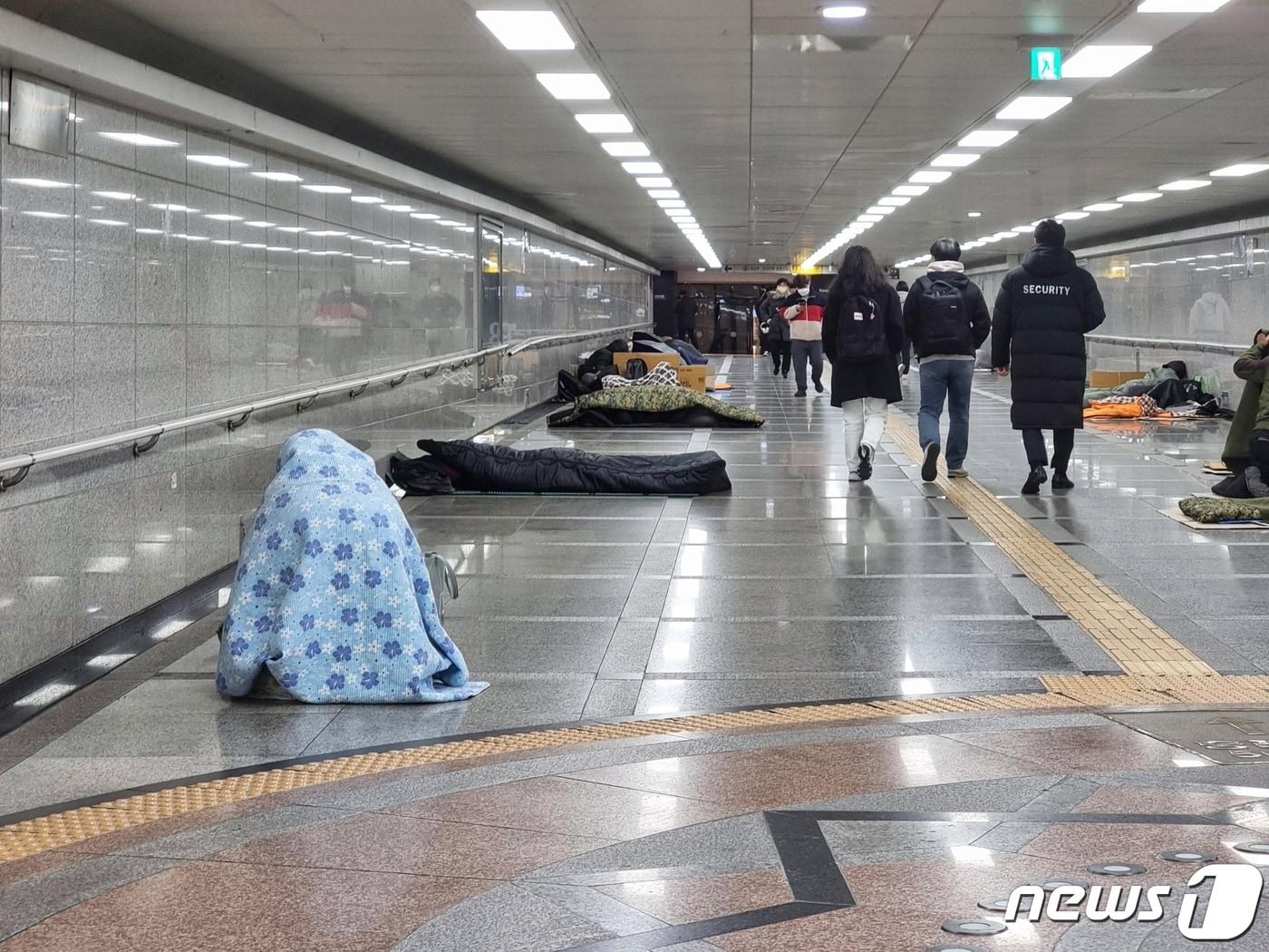 본문 이미지 - 서울 중구 서울역 지하상가에 노숙인들이 이불로 한기를 막고 있다. 2023.11.30/뉴스1 ⓒ News1 황덕현 기후환경전문기자