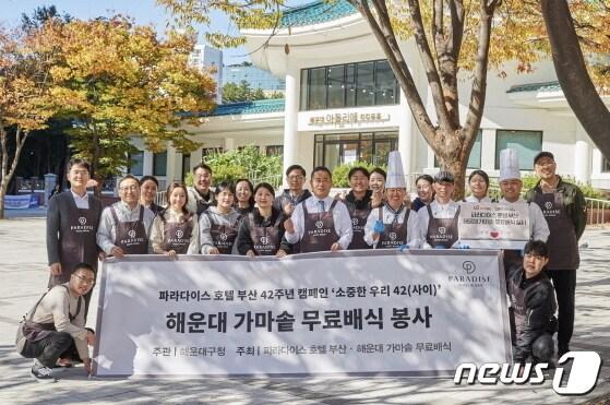 본문 이미지 - 7일 부산 해운대구 우동 무료 배식 봉사활동 현장에서 윤진상 파라다이스 호텔 부산 총지배인(첫줄 오른쪽 네번째)과 호텔 및 카지노 임직원이 기념촬영을 하고 있다(파라다이스 제공).