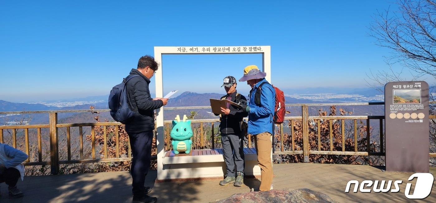 본문 이미지 - 용인시 관게자들이 광교산 등산로를 점검하고 있는 모습.(용인시 제공)