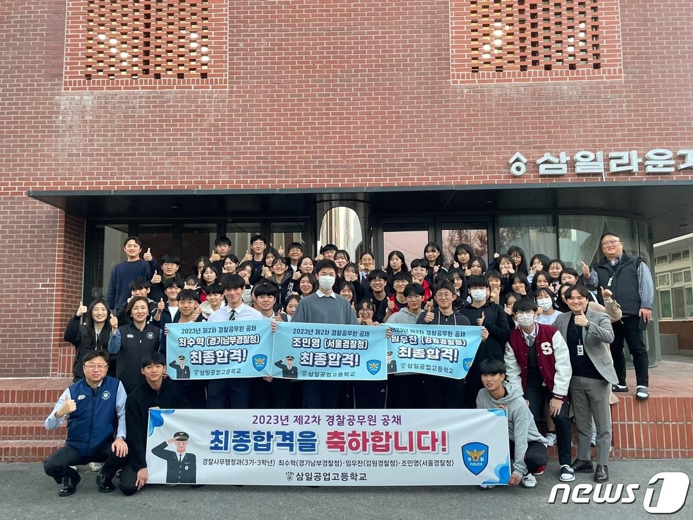 본문 이미지 - 삼일공고 학생들이  2023년 순경 공채 2차 시험에 합격한  이우찬, 최수혁, 조민영 학생 등 3명을 축하하며 기념촬영을 하고 있다. (삼일공고 제공)
