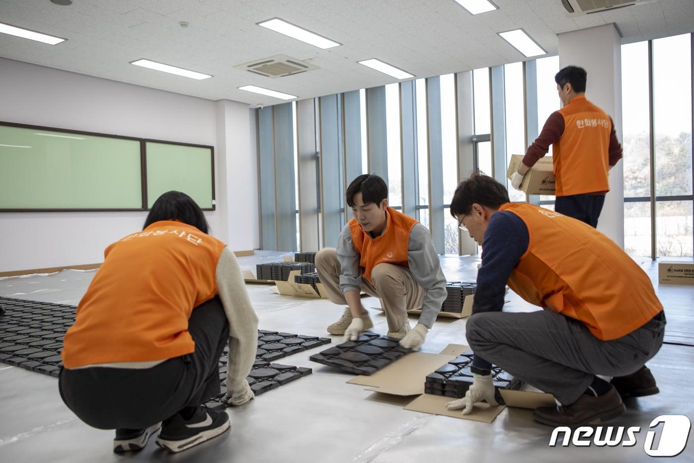 본문 이미지 - 한화토탈에너지스 직원들이 서울시사회복지협의회와 함께 마포 자활센터를 방문해 바닥 난방용 온돌매트를 설치하는 모습.(한화토탈에너지스 제공)/뉴스1