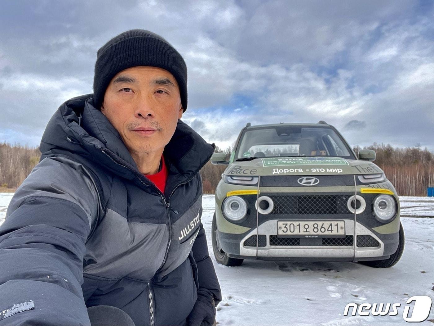 본문 이미지 - 시베리아 횡단 도로 중 아무르주 구간에서 캐스퍼와 기념촬영 중인 김현국 탐험가. /뉴스1
