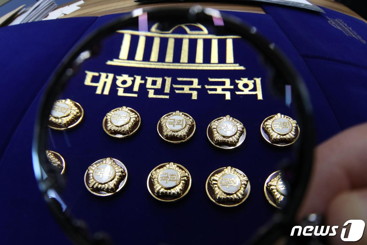 본문 이미지 - 국회 재입성을 노리며 경기지역 4·10총선 예비후보로 등록한 현역의원만 24명에 이르는 것으로 나타났다. 사진은 제22대 국회의원 선거(총선) 예비후보자 등록 시작일인 지난해 12월12일 서울 여의도 국회 사무처에서 한 직원이 국회의원 배지를 정리하고 있는 모습. 2023.12.12/뉴스1 ⓒ News1 임세영 기자