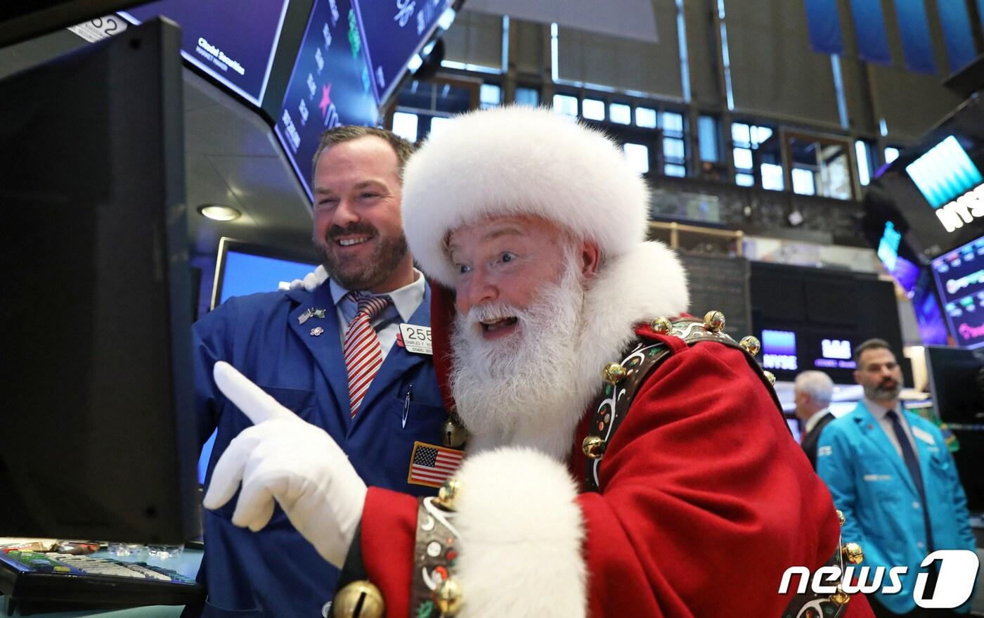 본문 이미지 - 미국 뉴욕증권거래소(NYSE)의 내부 객장에 산타클로스 복장의 한 남성이 트레이더와 함께 스크린을 보고 있다. 2018.11.21ⓒ 로이터=뉴스1
