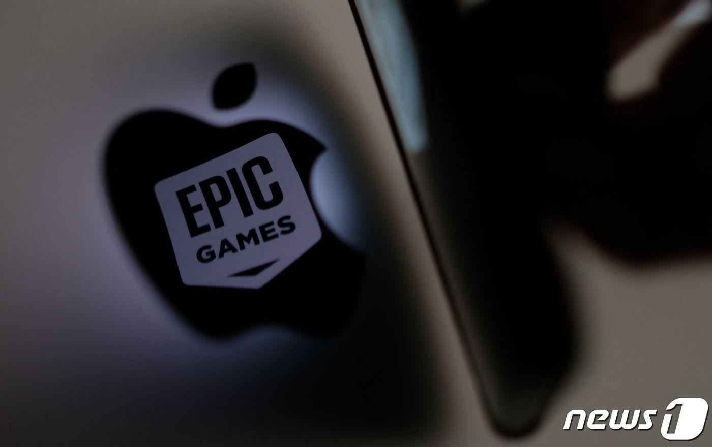 (FILES) This illustration photo shows the Epic Games logo reflecting onto the Apple logo of the back of an I-mac in Los Angeles on May 3, 2021 (Photo by Chris DELMAS / AFP) ⓒ AFP=뉴스1