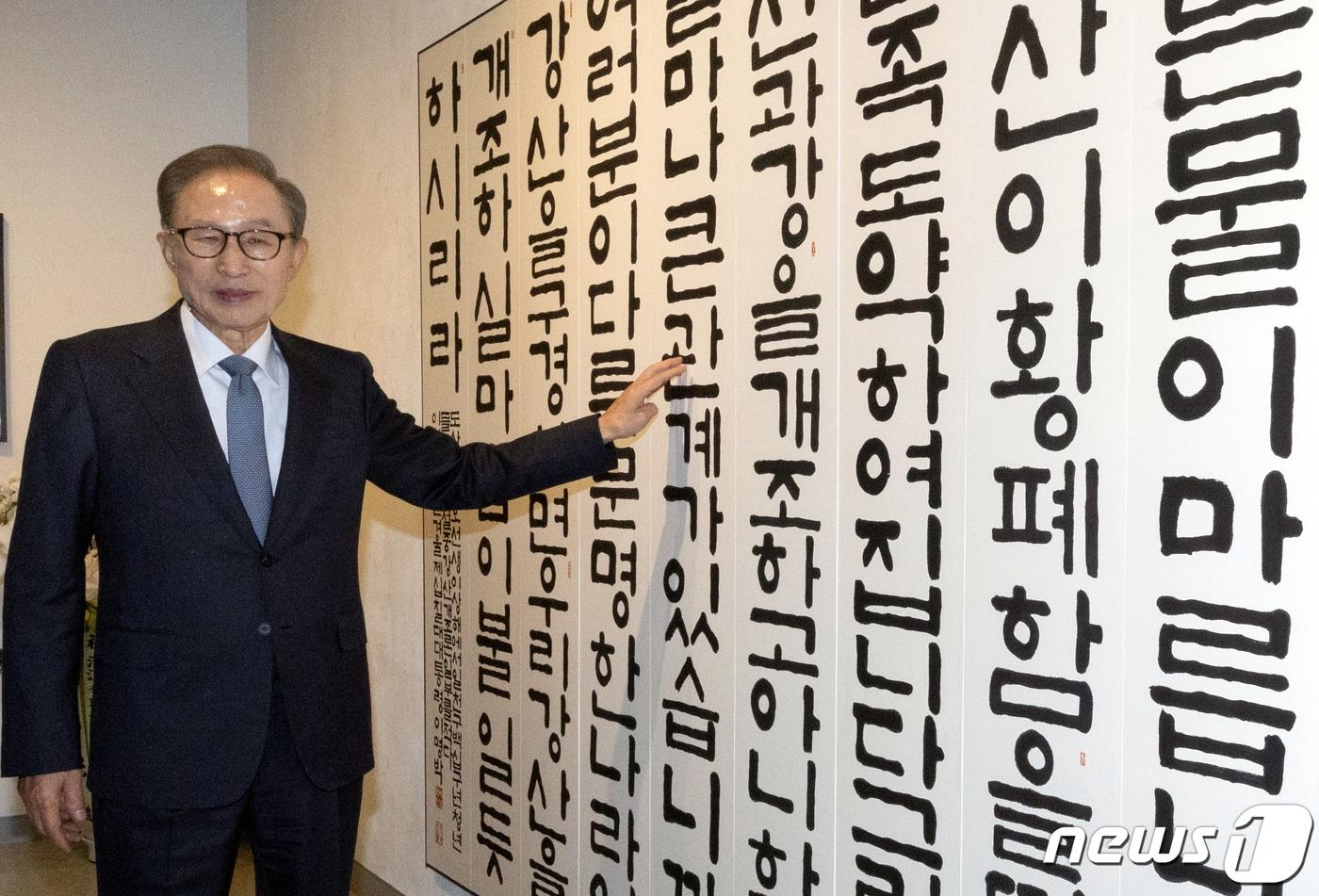 본문 이미지 - 이명박 전 대통령이 13일 오후 서울 서초구 한전아트센터에서 열린 첫 서예전 '스며들다' 개막식에서 자신에 작품을 배경으로 포즈를 취하고 있다. 2023.12.13/뉴스1 ⓒ News1 이재명 기자