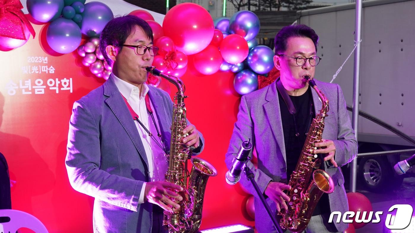 광주시교육청이 14일 시교육청 본관 중앙화단에서 직장동호회 성과발표회를 겸한 송년음악회를 갖고 직원들이 직접 공연을 펼치고 있다.색소폰 부는 박철신 정책국장(오른쪽)과 홍기승 장학관. (광주시교육청 제공)2023.12.15./뉴스1