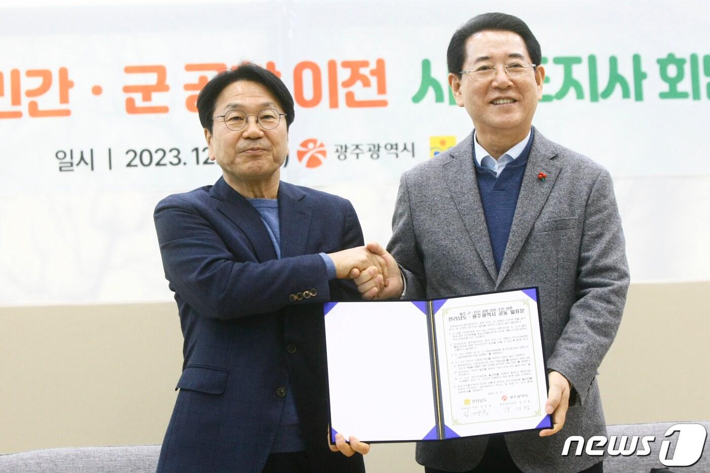 본문 이미지 - 강기정 광주시장(왼쪽)과 김영록 전남지사가 17일 오후 나주 혁신도시 내 한국농수산식품유통공사 회의실에서 광주 군·민간공항 이전과 관련해 공동발표문에 서명 후 악수하고 있다. 2023.12.17/뉴스1 ⓒ News1 김태성 기자