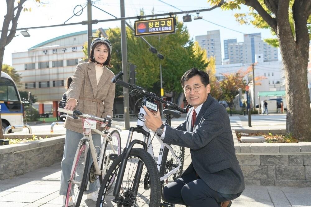 본문 이미지 - 이기재 양천구청장이 '자전거 지킴이 솔루션 존'에서 전자칩이 내장된 자전거번호판을 구민과 함께 부착하고 있다.(양천구청 제공)