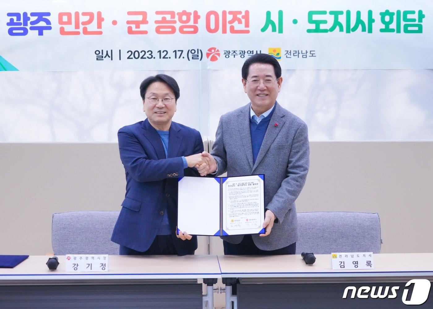 본문 이미지 - 강기정 광주시장과 김영록 전남도지사가 지난해 12월 17일 오후 전남 나주혁신도시 한국농수산식품유통공사(AT)에서 만나 광주 군·민간 공항 이전 추진 관련 논의를 마친 뒤 공동발표문을 들고 기념촬영을 하고 있다.(광주시 제공)2023.12.18/뉴스1 