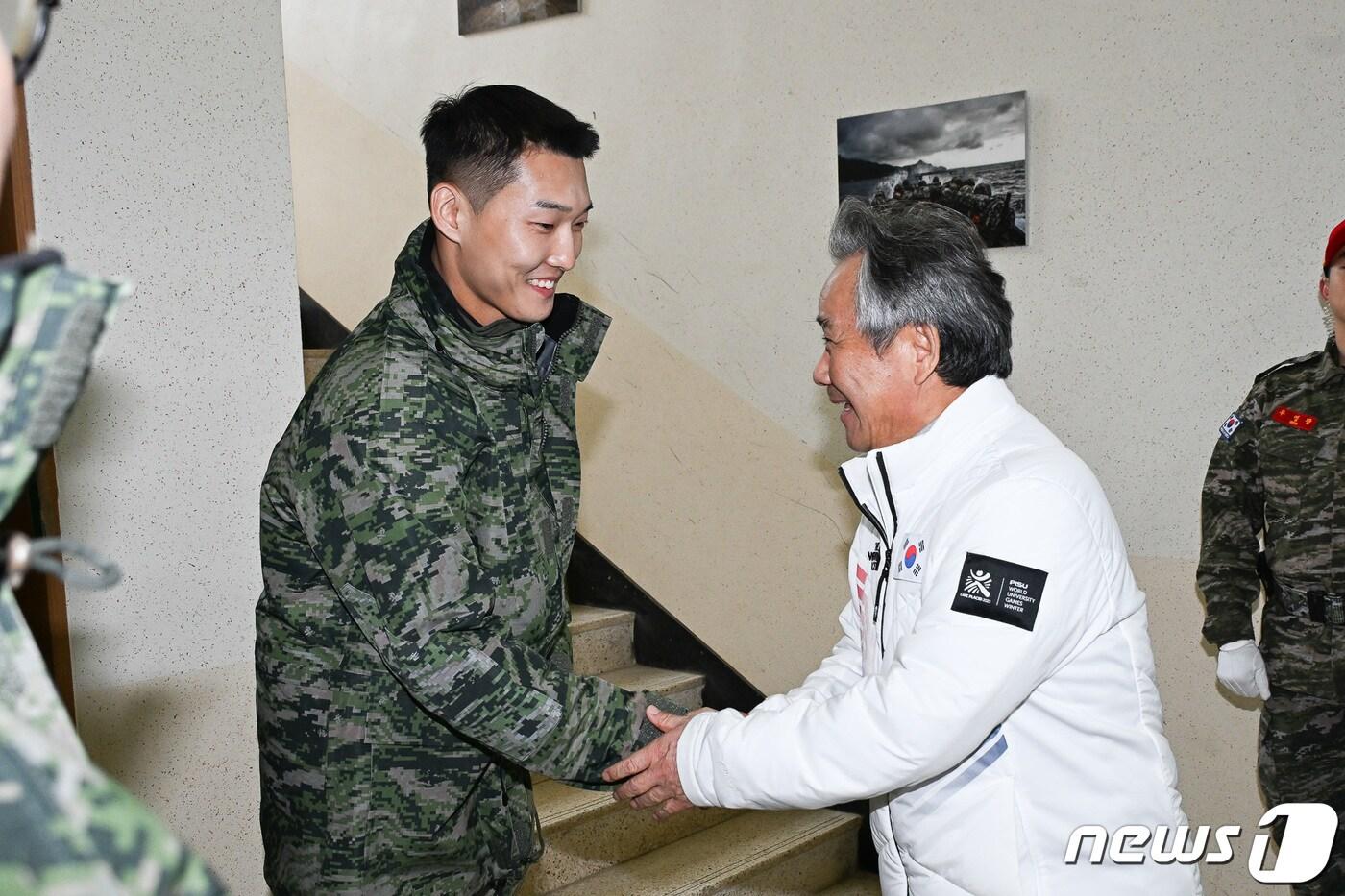 본문 이미지 - 이기흥 대한체육회장이 18일 포항 해병대 1사단에서 열린 국가대표 선수단 '원 팀 코리아' 캠프 입소식에 참석해 육상 우상혁 선수와 악수하고 있다. (대한체육회 제공) 2023.12.18/뉴스1