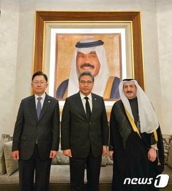 본문 이미지 - 2023년 12월 18일 박진(가운데) 당시 외교부 장관, 정병하(왼쪽) 주쿠웨이트대한민국 대사, 디얍 파르한 알 라쉬디 주한쿠웨이트대사와 향년 86세로 서거한 세이크 나와프 쿠웨이트 군주(에미르) 초상화 앞에 자리하고 모습. (외교부 제공)