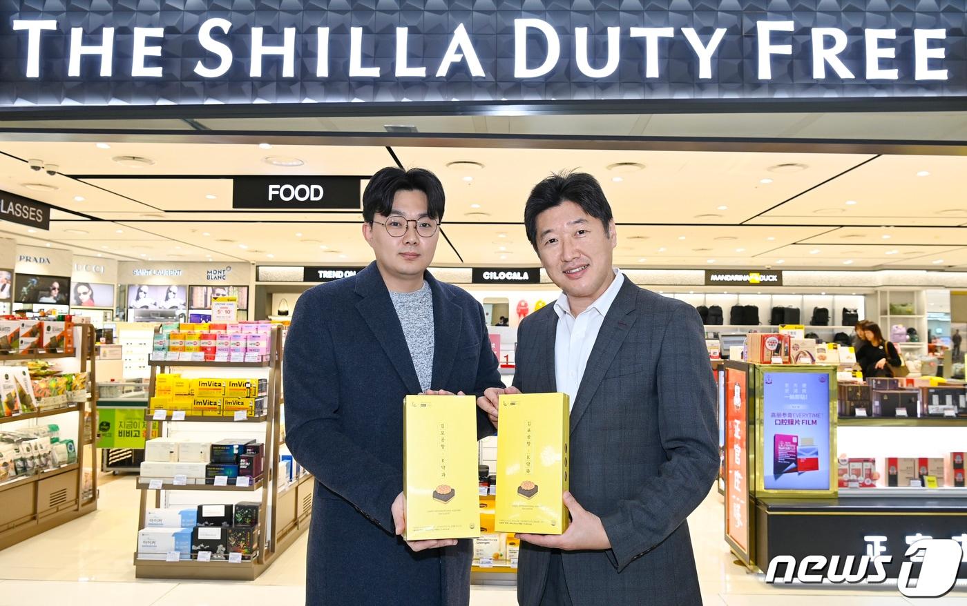 본문 이미지 - 정동성 신라면세점 김포공항점장(오른쪽)이 정상범 한국공항공사 컨세션사업부 차장과 '김포공항 K약과' 출시 기념 사진촬영을 하고 있다(호텔신라 제공).