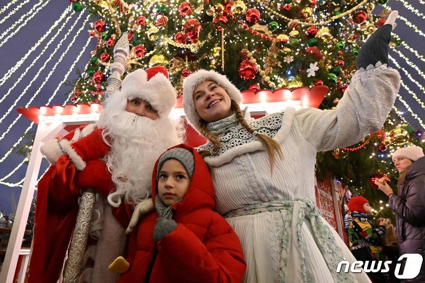 17일(현지시간) 러시아 모스크바에서 한 어린이가 산타클로스와 러시아 동화 주인공과 함께 사진을 찍고 있다. 2023.12.17 ⓒ AFP=뉴스1 ⓒ News1 정지윤 기자
