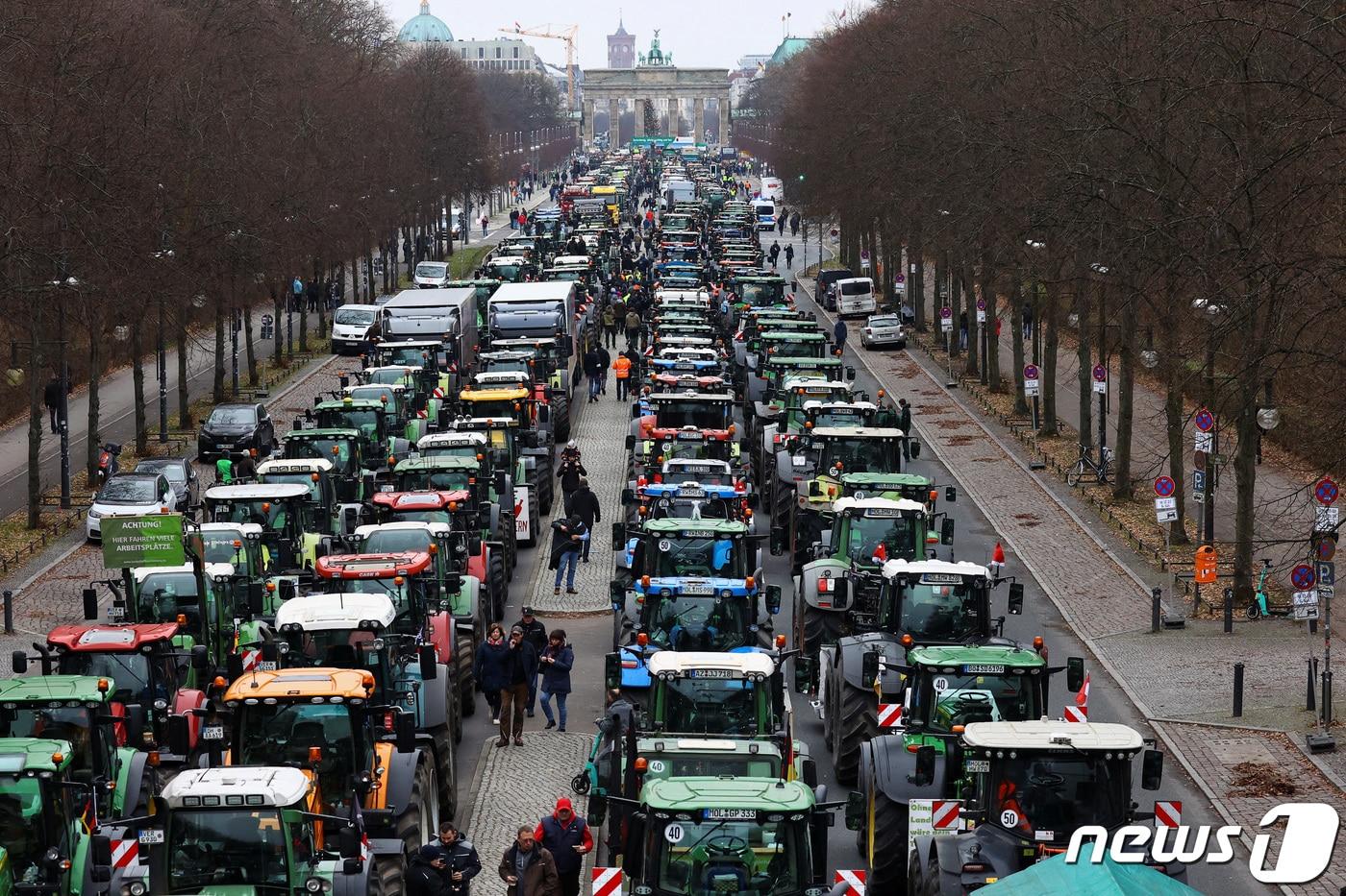 본문 이미지 - 18일(현지시간) 독일 베를린 브란덴부르크 문 근처에서 독일 농민들이 자동차세 보조금 삭감에 반대하는 시위에 참여하며 트랙터를 몰고 와 줄지어 서있다. 2023.12.18 ⓒ 로이터=뉴스1 ⓒ News1 정지윤 기자