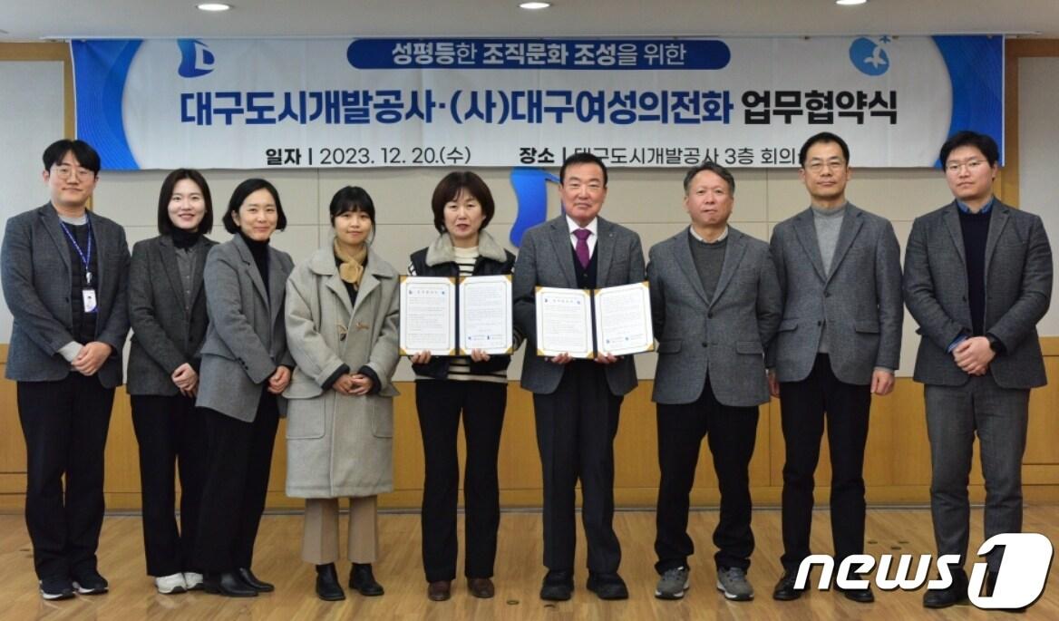 본문 이미지 - 정명섭 대구도시개발공사장(오른쪽 네번째)과 송경인 대구여성의전화 대표(왼쪽 다섯번째)가 '성평등한 조직문화 조성'을 위한 업무협약을 체결한 뒤 협약서를 펼쳐 보이고 있다.(대구도시개발공사 제공)