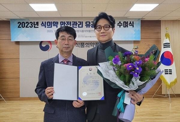 본문 이미지 - 이성도 경인식품의약품안전청장(왼쪽)이 강기문 크래프트브로스 대표(오른쪽)에게 표창장을 수여한 뒤 기념촬영을 하고 있다. (사진제공=크래프트브로스)