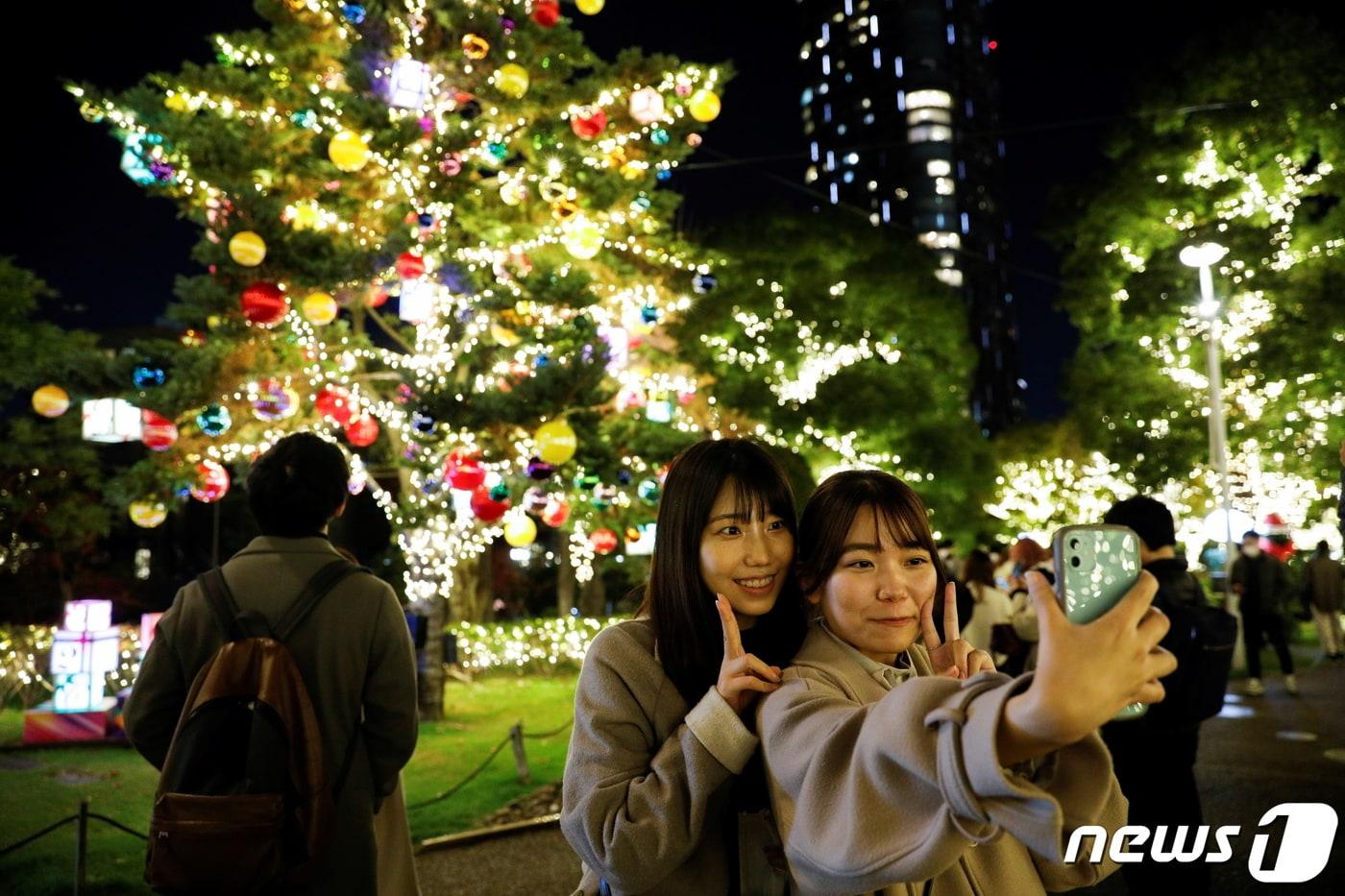 본문 이미지 - 23일 일본 도쿄에서 시민들이 화려한 크리스마스 트리 앞에서 사진을 찍고 있다. 2021.11.23/ ⓒ 로이터=뉴스1 ⓒ News1 박재하 기자