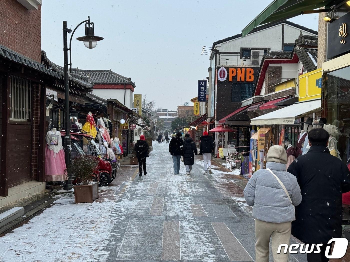 본문 이미지 - 성탄절인 25일 오전 전북 전주시 풍남동 한옥마을에서 관광객들이 눈 덮인 거리를 거닐고 있다..2023.12.25./뉴스1 김경현 수습기자