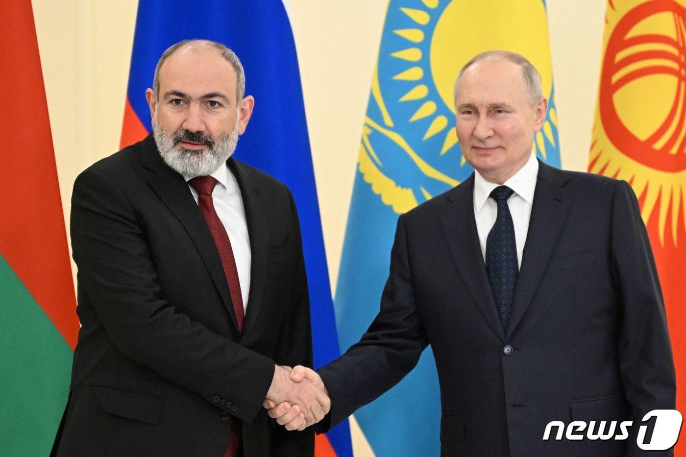 본문 이미지 - 블라디미르 푸틴 러시아 대통령이 25일 (현지시간) 상트페테르부르크에서 열린 유라시아 경제연합 정상회의의 최고 유라시아 경제 위원회 회의에 앞서 니콜 파쉬냔 아르메니아 총리와 악수를 하고 있다. 2023.12.26 ⓒ AFP=뉴스1 ⓒ News1 우동명 기자