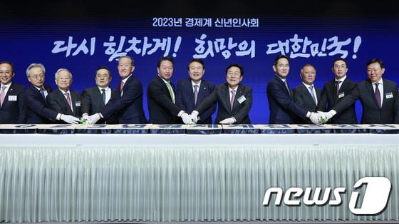 본문 이미지 - 윤석열 대통령과 최태원 대한상의 회장을 비롯한 참석자들이 2023년 경제계 신년인사회에서 떡을 자르고 있다. 왼쪽부터 이재하 대구상의 회장, 추경호 경제부총리, 최진식 중견기업연합회 회장, 손경식 경총 회장, 구자열 무역협회 회장, 허창수 전경련 회장, 최태원 대한상의 회장, 윤석열 대통령, 김기문 중기중앙회 회장, 이재용 삼성전자 회장, 정의선 현대차 회장, 구광모 LG 회장, 신동빈 롯데 회장, 이영 중소벤처기업부 장관. (대한상의 제공) 2023.1.2/뉴스1