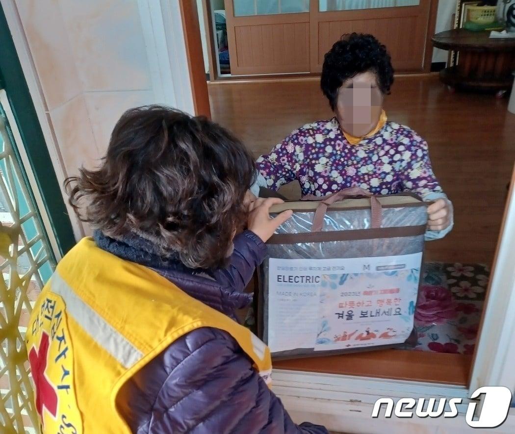 본문 이미지 - 경남적십자가 27일 창원 취약계층 667세대에 난방비 1억원을 지원했다. 사진은 적십자 봉사원이 도내 취약계층에 전기요 매트를 전달하는 모습.&#40;경남적십자 제공&#41;