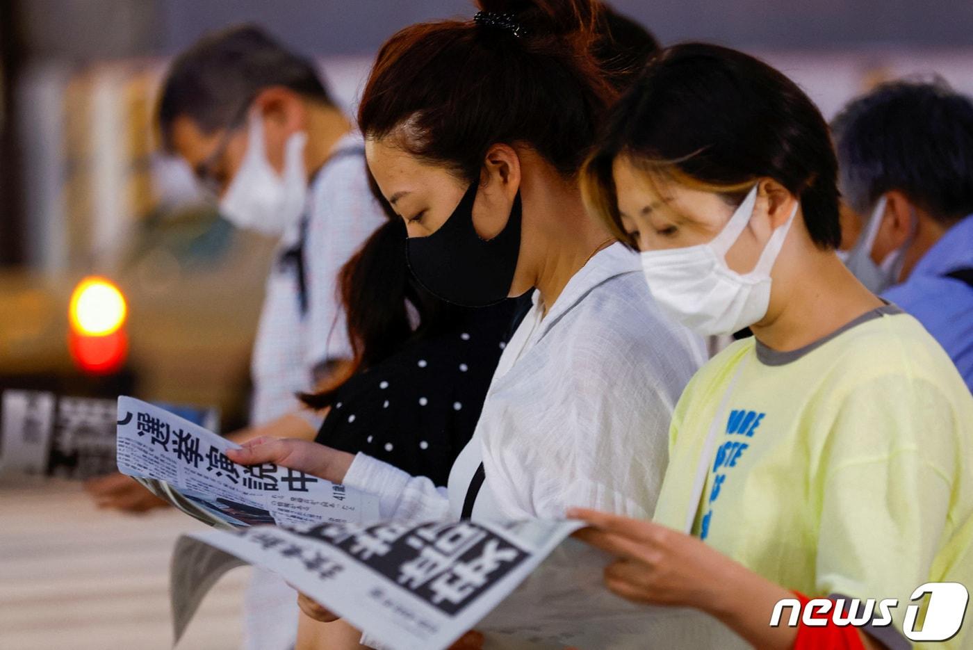 본문 이미지 - 일본 도쿄에서 시민들이 아베 신조 전 총리의 사망 기사가 실린 신문을 읽고 있다. 2022.07.08/ ⓒ 로이터=뉴스1 ⓒ News1 권진영 기자