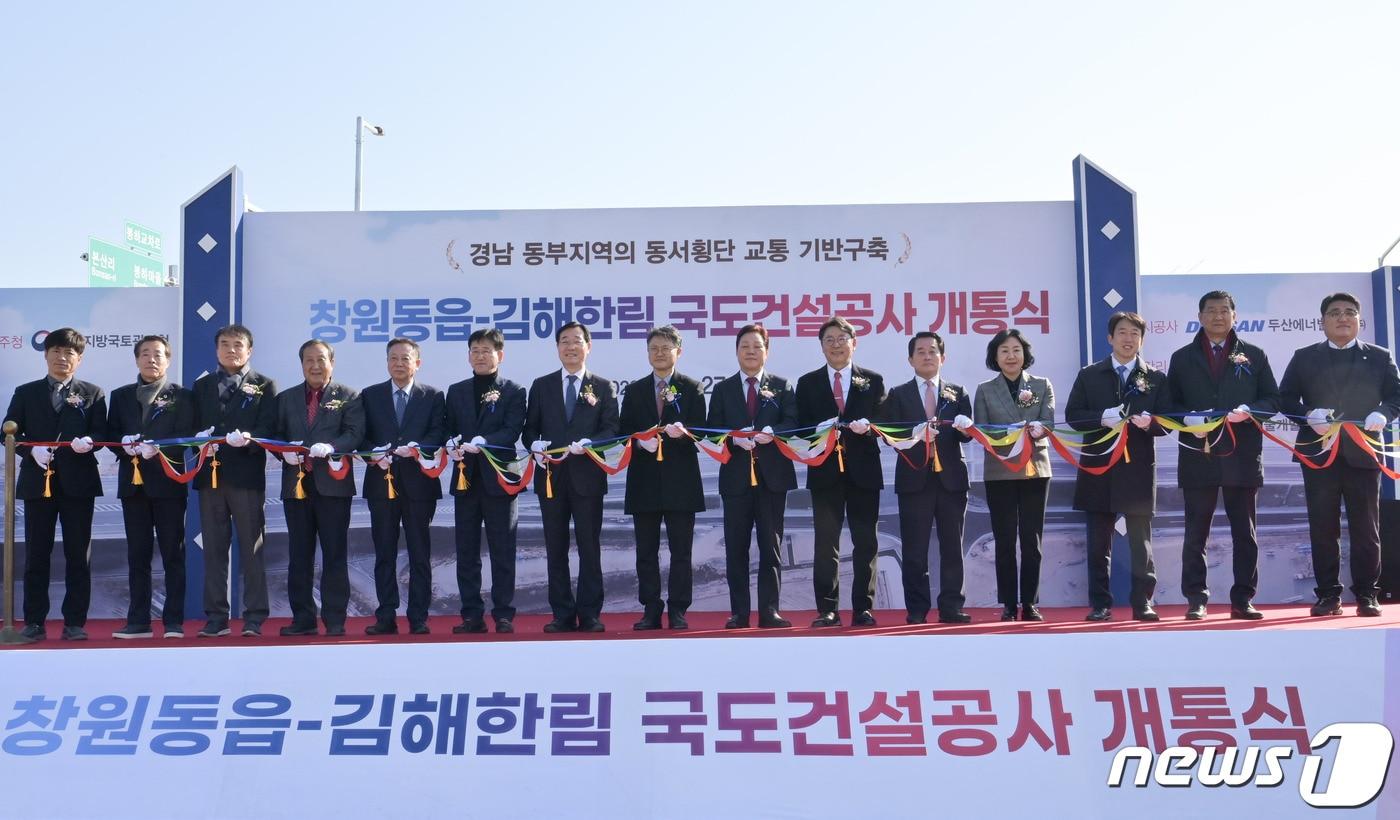 본문 이미지 - 27일 경남 김해시 진영읍 금봉휴게소에서 열린 ‘국도14호선 창원 동읍~김해 한림간 도로’ 개통식 참석자들이 테이프 커팅식을 하고 있다.(경남도 제공)