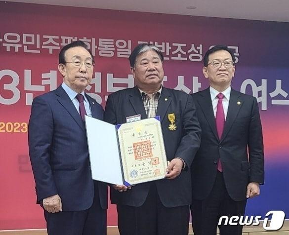 본문 이미지 - 민주평화통일자문회의 양산시협의회 박말태 고문(가운데)이 2023년도 정부포상 수여식에서 윤석열 대통령으로부터 국민훈장 목련장을 수훈하는 영예를 안았다. (양산시 제공)