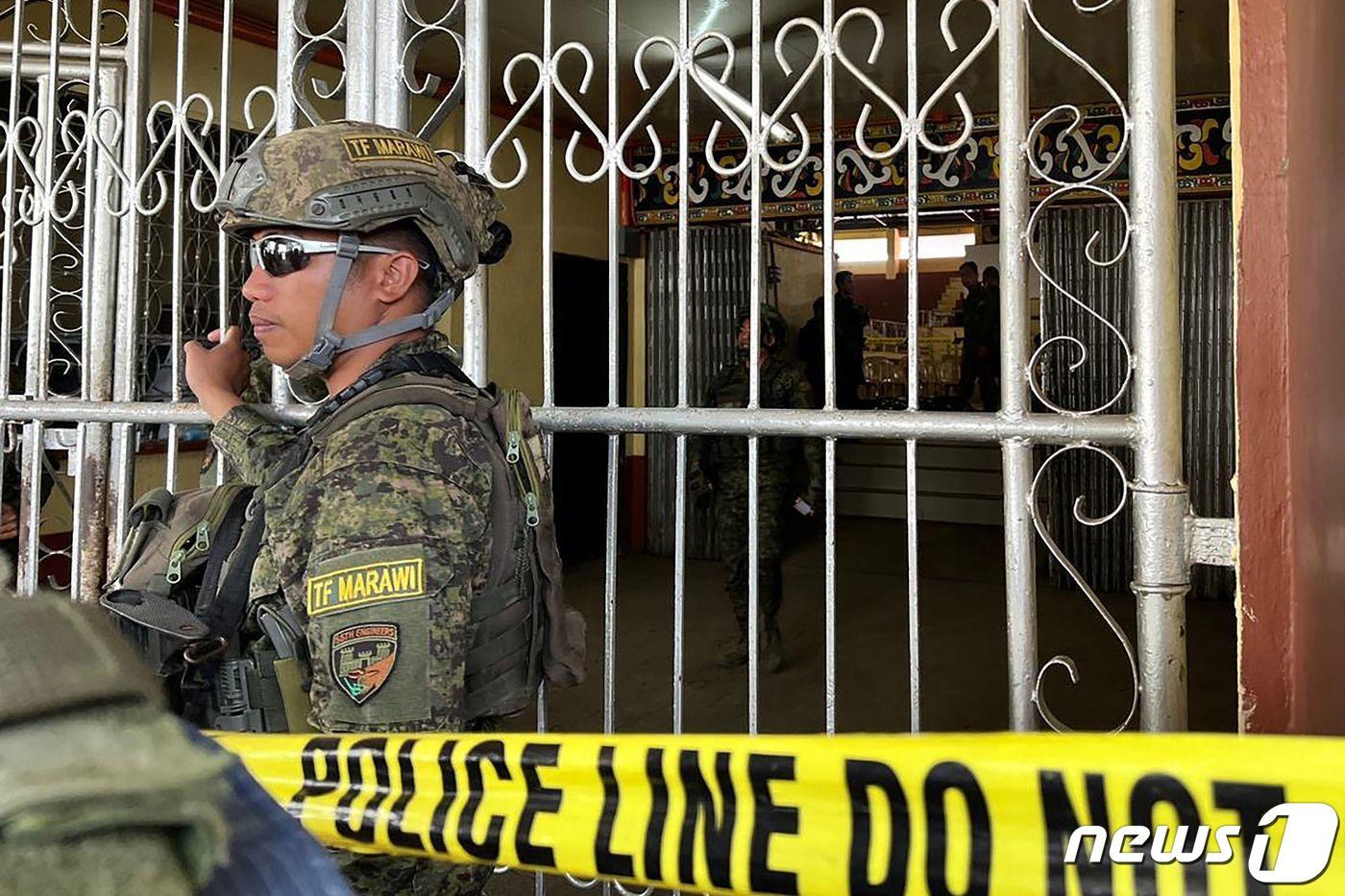 본문 이미지 - 3일(현지시간) 필리핀 민다나오섬 라나오델수르주 주도 마라위의 민다나오주립대(MSU) 체육관에서 폭발이 일어나 경찰 수사관들이 증거를 찾는 동안 군인들이 체육관 입구에서 경비를 서고 있다. 2023.12.03 ⓒ AFP=뉴스1 ⓒ News1 정지윤 기자