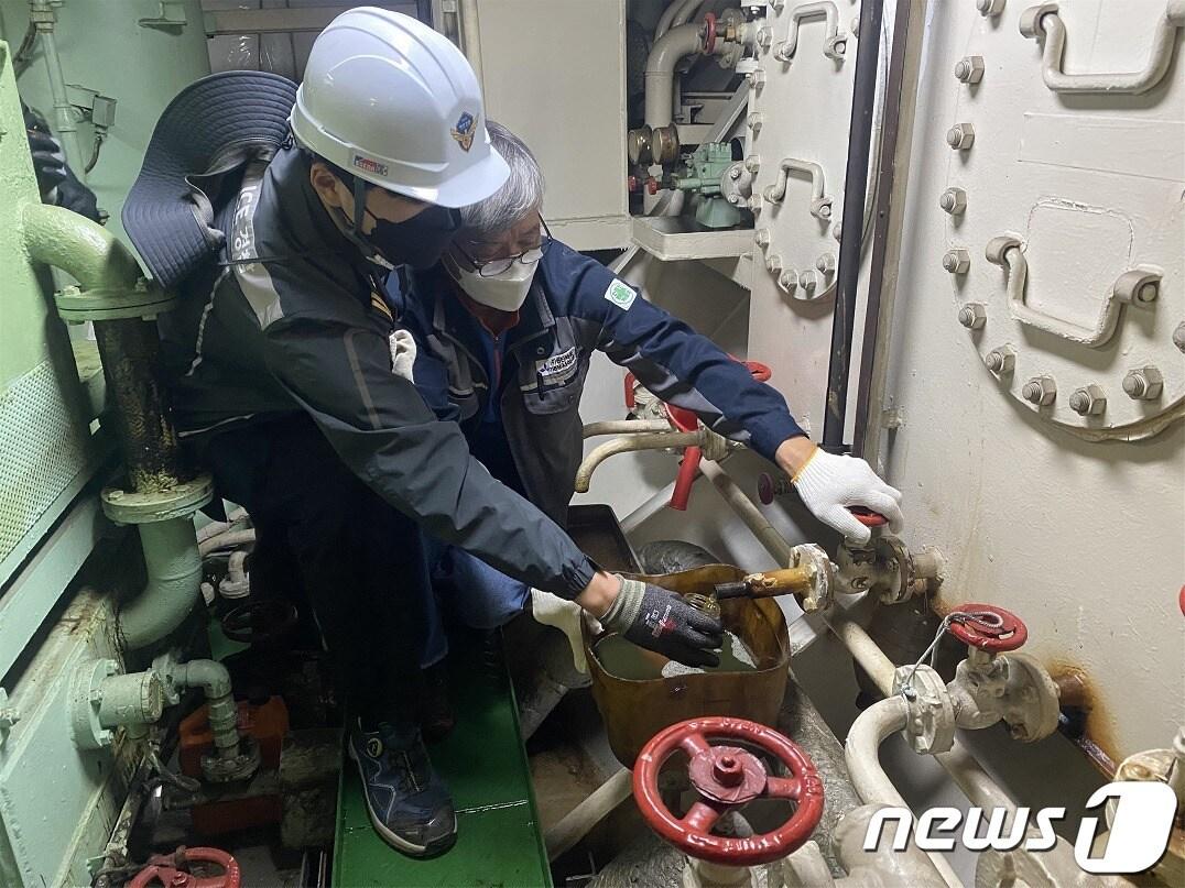 본문 이미지 - 남해해경청 관계자가 선박 연료유 시료를 채취하고 있다. &#40;남해해경청 제공&#41;