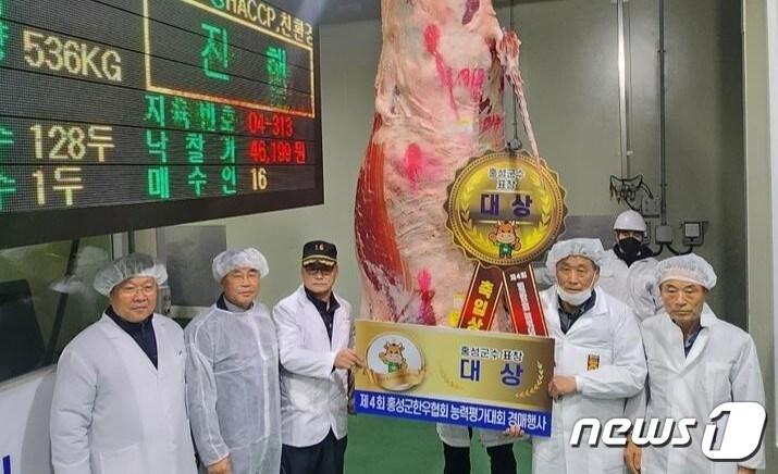 본문 이미지 - 지난 4일 열린 홍성한우 한우능력평가대회에서 관계자들이 대상을 받은 문신영씨(오른쪽 두번째)와 기념촬영을 하고 있다.(홍성군 제공)/뉴스1