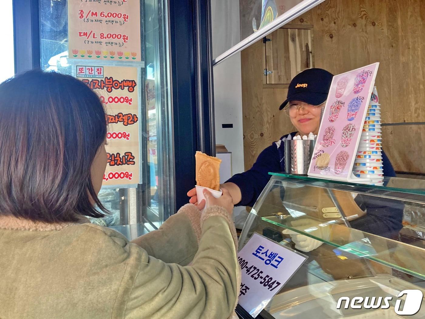 본문 이미지 - 5일 광주 동구 충장로 한 붕어빵 가게에서 종업원이 주문 들어온 붕어빵을 건네고 있다. 2023.12.5/뉴스1 ⓒ News1 조현우 인턴기자