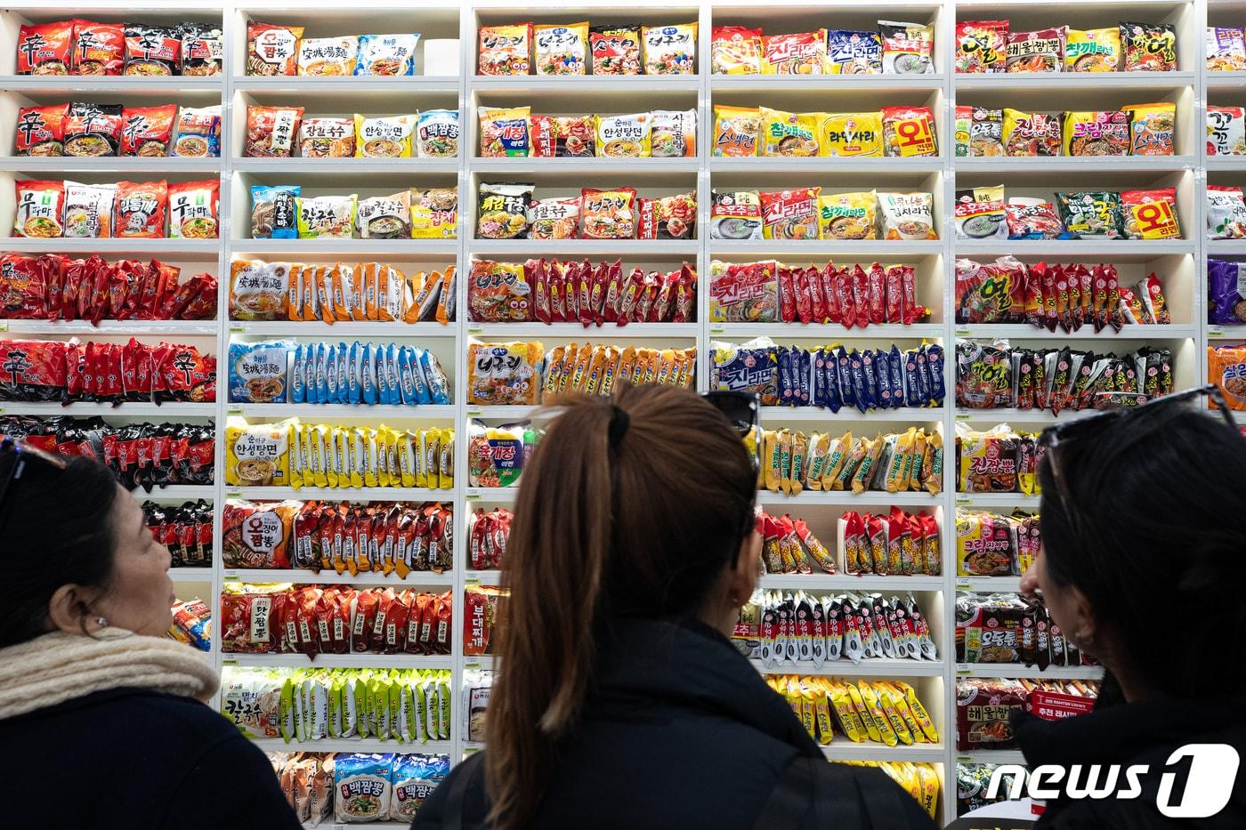 서울 마포구 CU홍대상상점에 마련된 '라면 라이브러리'를 찾은 외국인 관광객들이 다양한 라면을 살펴보고 있다. 2023.12.5/뉴스1 ⓒ News1 유승관 기자