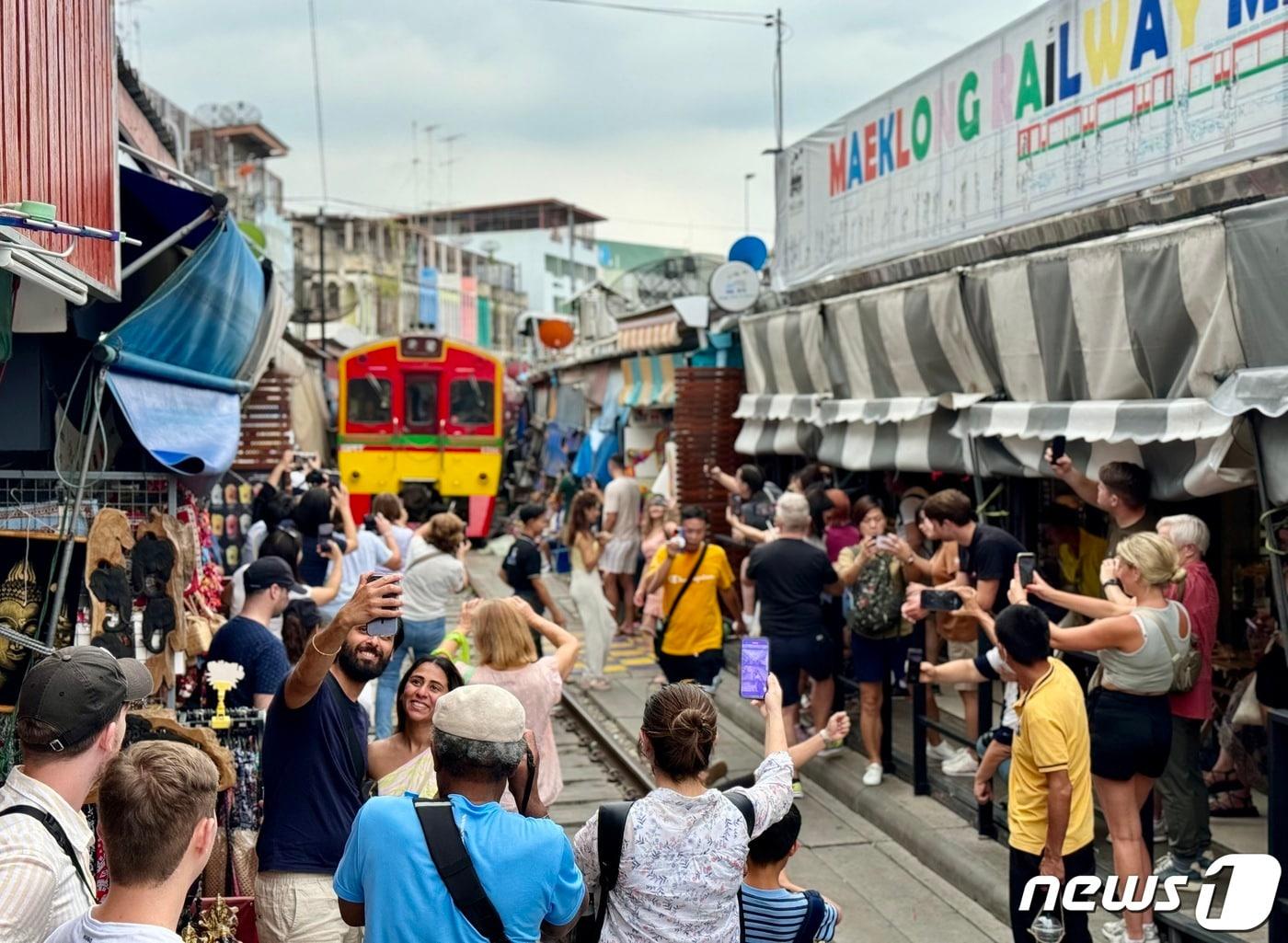 본문 이미지 - 태국 암파와에 있는 '매끌렁 기찻길 시장'에 열차가 지나가는 모습 ⓒ News1 이민주 기자