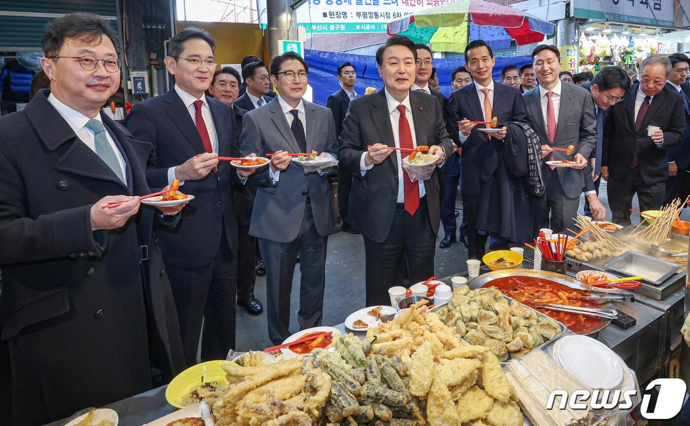본문 이미지 - 윤석열 대통령이 6일 부산 중구 깡통시장을 방문해 박형준 부산시장과 이재용 삼성전자 회장, 구광모 LG그룹 회장, 조현준 효성그룹 회장, 김동관 한화그룹 부회장, 최재원 SK수석부회장 등 기업총수들과 함께 떡볶이, 튀김, 빈대떡을 맛보고 있다. 2023.12.6/뉴스1 ⓒ News1 부산사진공동취재단