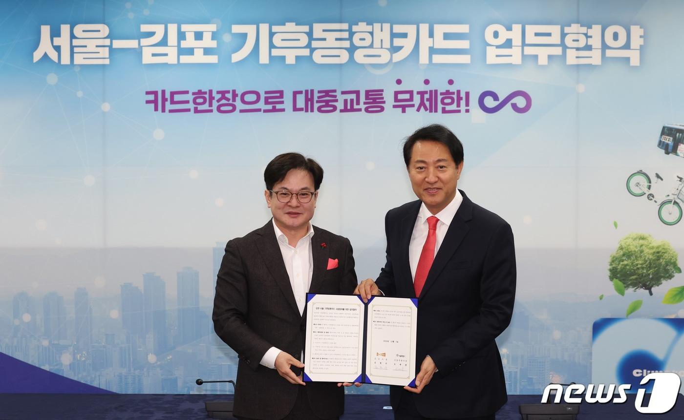 본문 이미지 - 오세훈 서울시장과 김병수 김포시장이 7일 오전 서울 중구 서울시청에서 열린 서울·김포 기후동행카드 업무협약식에서 협약서 서명을 마치고 기념촬영을 하고 있다. 2023.12.7/뉴스1 ⓒ News1 김민지 기자
