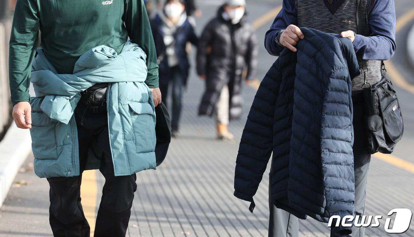 본문 이미지 - 눈이 가장 많이 내린다는 절기상 대설인 7일 오후 서울 용산구 남산타워를 찾은 시민이 외투를 들고 발걸음을 옮기고 있다. 2023.12.7/뉴스1 ⓒ News1 김민지 기자