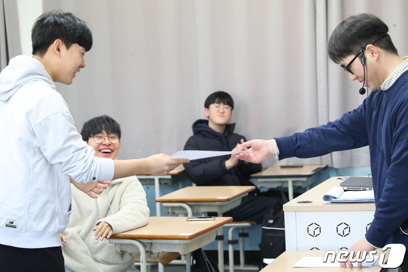 본문 이미지 - 2024학년도 대학수학능력시험 성적표가 배부된 8일 오전 광주 광산구 정광고등학교에서 고3 수험생들이 담임선생님으로부터 수능 성적표를 받고 있다. 2023.12.8/뉴스1 ⓒ News1 김태성 기자