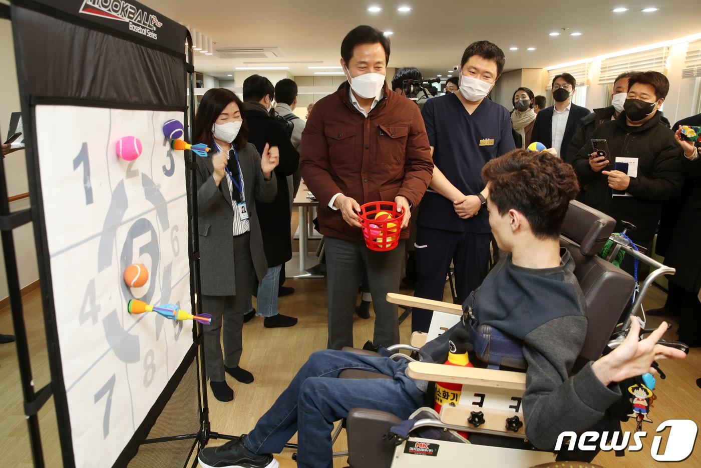 오세훈 서울시장이 서울 강동구 중증뇌병변장애인 긴급수시돌봄 한아름 단기거주시설을 방문, 시설 이용자인 김우솔 씨의 손근육 재활운동 모습을 지켜보고 있다. (공동취재) 2023.2.1/뉴스1 ⓒ News1 이승배 기자