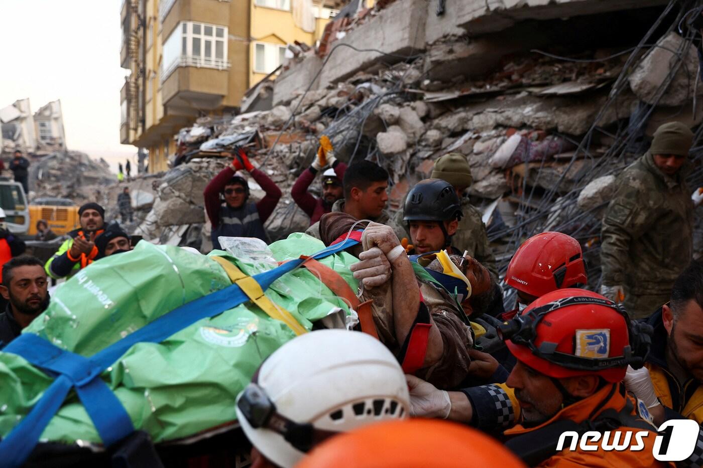 규모 7.8 강진이 발생한 지 닷새째인 10일(현지시간) 튀르키예 카라만라스에서 튀르키예와 이스라엘 구조 대원들이 건물 잔해에 깔려 있던 알리 코르크마즈(56)를 구출한 뒤 들것에 실어 이송하고 있다. 2023.2.10. ⓒ 로이터=뉴스1 