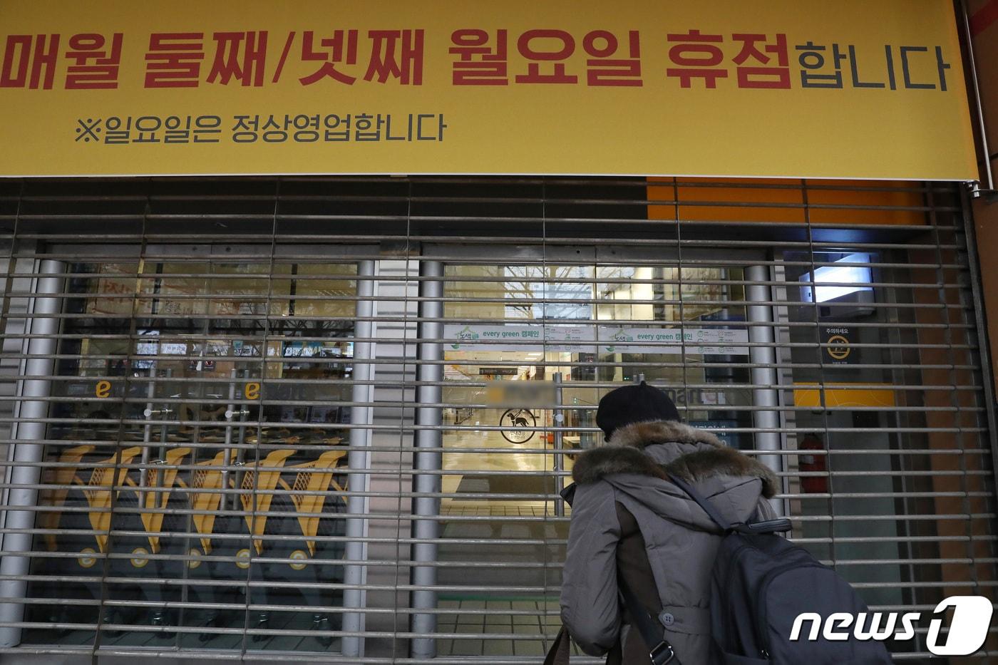 대구 지역의 대형마트 의무휴업일이 일요일에서 평일인 월요일로 변경된 13일 오후 휴점에 들어간 대구 수성구 한 대형마트 출입문이 닫혀 있다. 휴업일 변경을 모른 채 장을 보기 위해 마트를 찾은 한 시민이 문 닫은 마트 내부를 바라보고 있다. 2023.2.13/뉴스1 ⓒ News1 공정식 기자