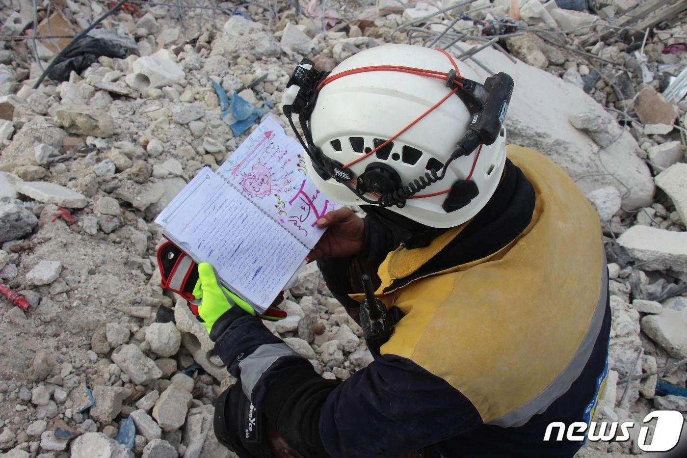 13일(현지시간) 시리아 민간구조대 화이트헬멧이 구조 작업 현장에서 일기장을 발견했다. 화이트헬멧은 일기장에 지진과 내전으로 폐허가 되기 전 시리아에서의 삶이 담겼다고 전했다. (화이트헬멧 트위터 갈무리)