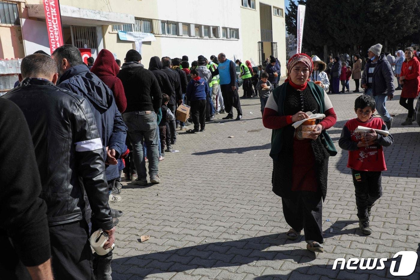 14일 (현지시간) 규모 7.8의 지진이 강타한 튀르키예 가지안테프주 이슬라히예 에서 이재민들이 음식을 배급 받기 위해 줄을 서 있다. ⓒ AFP=뉴스1 ⓒ News1 우동명 기자