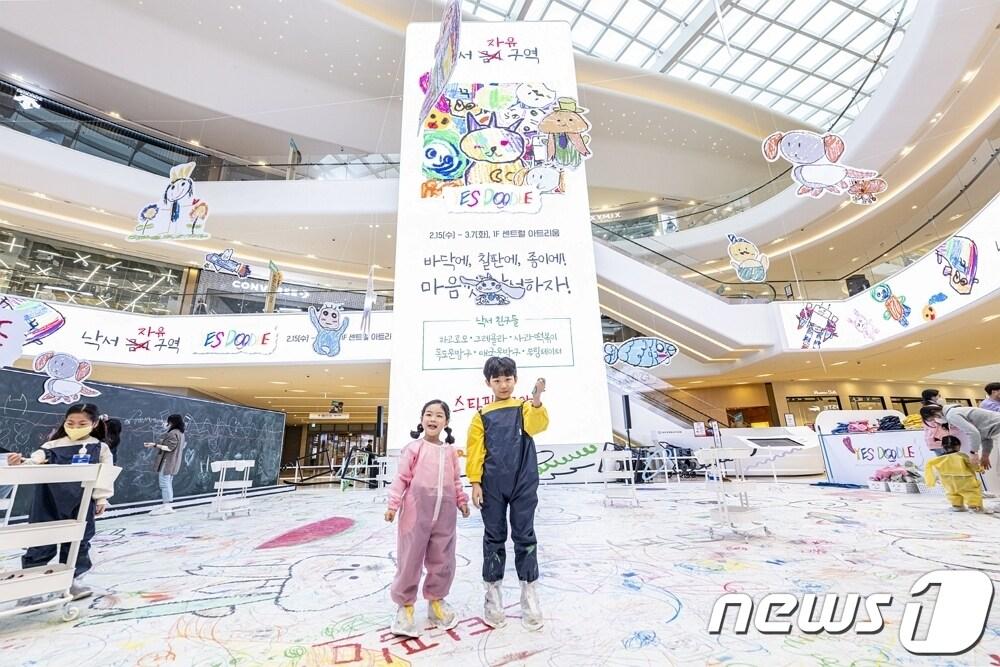 본문 이미지 - 경기 스타필드 고양 센트럴 아트리움에서 열린 '예스 두들' 행사에 참여한 어린이들이 낙서장에서 포즈를 취하고 있다(신세계프라퍼티 제공).